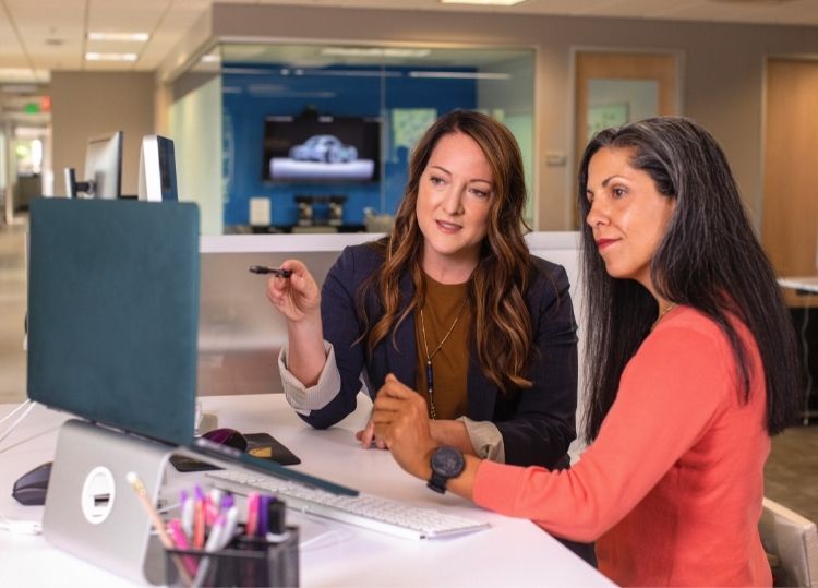 two women looking at a computer screen