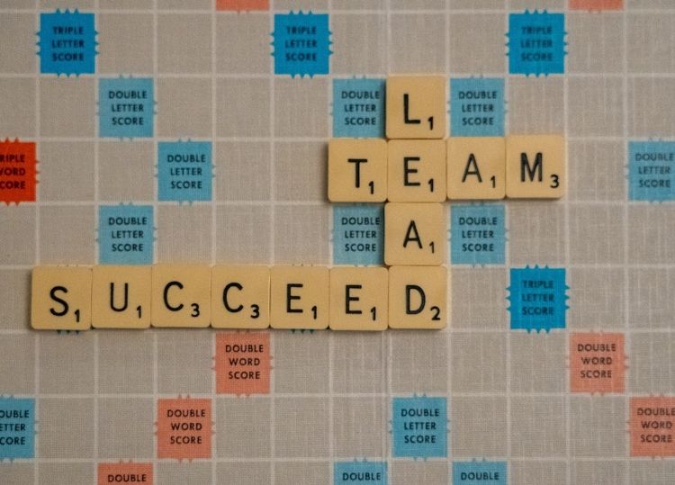 tiles spelling lead, team and succeed on scrabble board